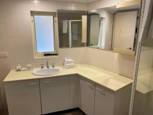 a bathroom with a sink and a mirror at Wahroonga Furnished Apartments in Hornsby