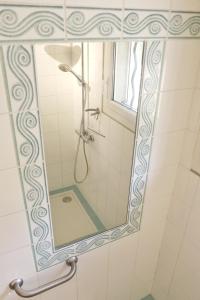 La salle de bains est pourvue d'un miroir et d'une douche. dans l'établissement CHEZ NOUCETTE, à Saint-Cyr-sur-Mer