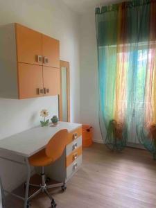 um quarto com uma secretária e uma cómoda com uma cortina de arco-íris em Carla's House em Bolsena