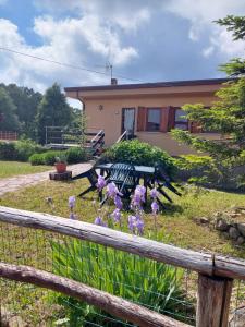 einen Zaun mit lila Blumen vor einem Haus in der Unterkunft Chalet Grazia in Valgiano