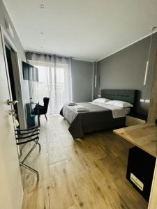 una camera con letto, sedia e scrivania di Aqua B&B - Rooms and Apartments a Milazzo