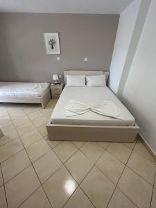 a bedroom with a bed and a tiled floor at Koks’ Guesthouse in Himare