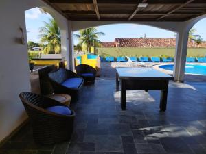 d'une terrasse avec une table et des chaises à côté de la piscine. dans l'établissement Casa com Piscina 50000 litros Área Gourmet 3 Suites no Destacado, Bairro mais Nobre de Salinas, à Salinópolis