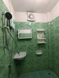 un bagno piastrellato verde con doccia e lavandino di Stay Hostel a Bangkok