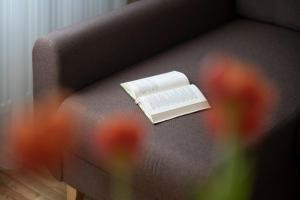 um livro sentado em cima de um sofá com flores em Villa ACACIA em Kaunas