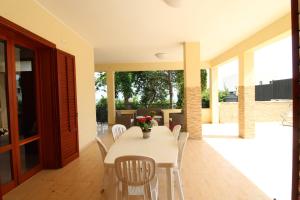 a dining room with a white table and chairs at AM Bonagia Valderice VILLA INTERA in Valderice