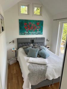 1 dormitorio con 1 cama y una pintura en la pared en Exclusive guesthouse with stunning Seaview!, en Värmdö