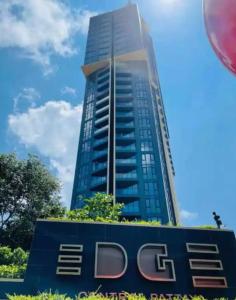a tall blue building with a sign in front of it at Edge Central PATTAYA SeaView Residence in Pattaya Central