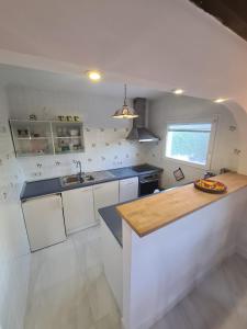 uma cozinha com armários brancos e um balcão de madeira em Villa Diana para 8 personas em Calpe
