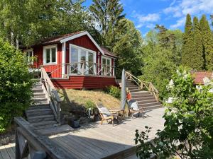 a red house with stairs leading up to it at Exclusive guesthouse with stunning Seaview! in Värmdö