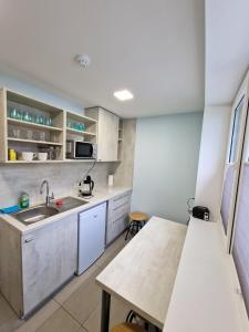 a small kitchen with a sink and a table at Editos apartamentai in Jurbarkas