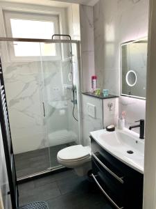 een badkamer met een douche, een toilet en een wastafel bij Résidence Stiénon in Brussel