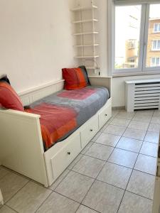 1 dormitorio con 1 cama en una habitación con ventana en Résidence Stiénon, en Bruselas