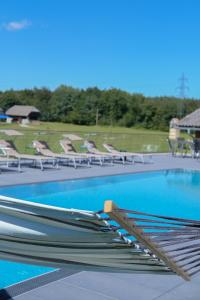 a swimming pool with a bunch of empty chairs at Keutschacherhof in Keutschach am See