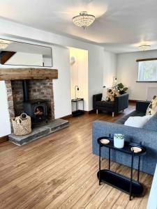 a living room with a couch and a fireplace at Hollins Cottage. Central location, Marple Bridge in Marple