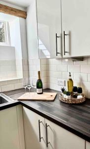 a kitchen with a counter with wine bottles and glasses at Hollins Cottage. Central location, Marple Bridge in Marple