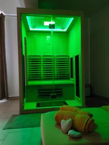 1 dormitorio con luz verde en una ventana en Chambre d'hôtes Tournesol, piscine en campagne gersoise, en Lias-dʼArmagnac