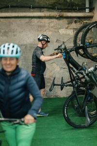 Dos hombres con cascos están trabajando en una bicicleta. en Der Hirschen, en Sankt Märgen