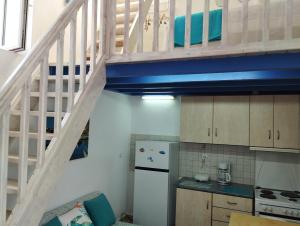 una cocina con una escalera que conduce a un loft en Mari...Milo en Péran Triovasálos