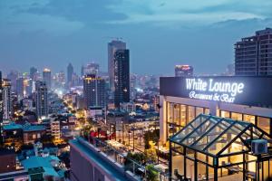 a city skyline at night with a white lounge building at Poulo Wai Hotel & Apartment in Phnom Penh