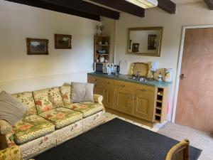 a living room with a couch and a kitchen at Southfields Farm in Nottingham