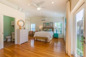 a bedroom with a bed and a dresser and a mirror at Pineapple Palms Resort Style Pool Villa! Sleeps 12 in West Palm Beach