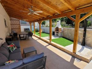an outdoor living room with a wooden pergola at Apartments Proxima in Trogir