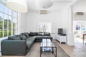 a living room with a couch and a table at Light Filled Spacious 1 Bedroom Haven in Cape Town