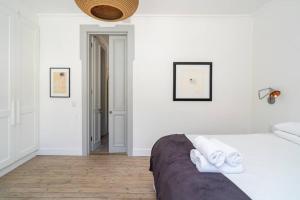 a white bedroom with a bed and a bathroom at Light Filled Spacious 1 Bedroom Haven in Cape Town