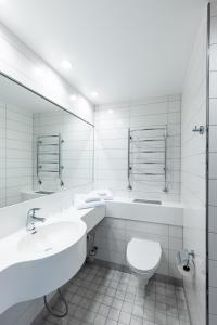 La salle de bains est pourvue de toilettes, d'un lavabo et d'un miroir. dans l'établissement Hotelli Siuntio, à Sjundeå