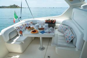 einen Tisch auf einem Boot mit einem Tablett mit Essen in der Unterkunft Taranto in barca Boat and Breakfast in Taranto