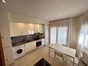 a kitchen and dining room with a table and chairs at Apartamentos TDM in Tossa de Mar