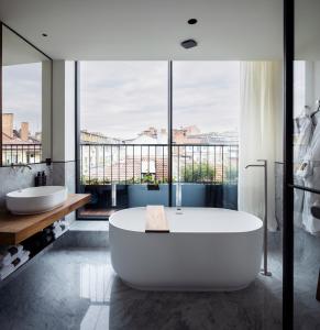 ein großes Badezimmer mit zwei Waschbecken und einer Badewanne in der Unterkunft Juno Hotel Sofia, a Member of Design Hotels in Sofia