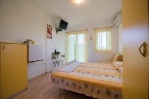 Apartmani Topolovec في Luka: غرفة نوم صغيرة بها سرير ومطبخ