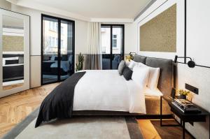 Schlafzimmer mit einem großen weißen Bett und Fenstern in der Unterkunft Juno Hotel Sofia, a Member of Design Hotels in Sofia
