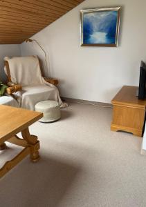 a living room with a table and a chair and a tv at Oberaudorf-Kaiserblick in Oberaudorf