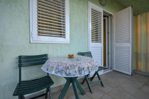 Apartmani Topolovec في Luka: طاولة وكراسي على فناء مع نافذة