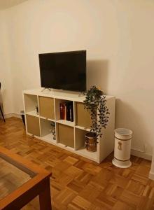 uma sala de estar com televisão num armário branco em La Cámara em Avilés