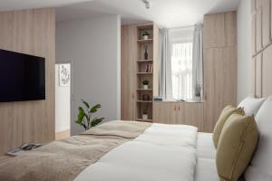 - une chambre avec un lit blanc et une télévision dans l'établissement U Pujcovny Apartment Old Town Prague, à Prague