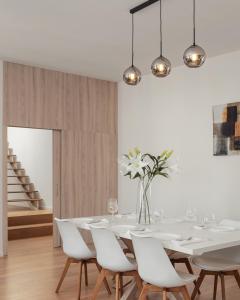 une salle à manger avec une table blanche et des chaises blanches dans l'établissement U Pujcovny Apartment Old Town Prague, à Prague