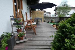 una passerella in legno con tavolo e ombrellone di Appartement Nummer 12 a Going