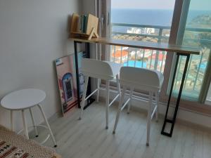 Haetmom House في جانجنيونج: طاولة وكرسيين في غرفة مع نافذة
