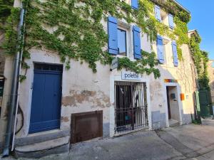a building with blue doors on a street at Cocon du Papillon à Lourmarin in Lourmarin