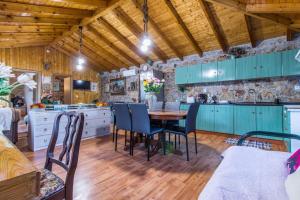cocina con armarios azules, mesa y sillas en Artemis Cottage Home, en Fréngaina