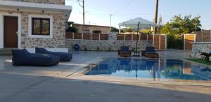 una piscina con 2 sillas y una sombrilla en Double Bee Villa with private pool, en Agios Konstantinos