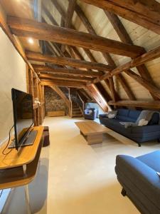 ein Wohnzimmer mit einem blauen Sofa und einem Tisch in der Unterkunft Maison de charme en Alsace - IN VINO VERITAS - 12 personnes in Gueberschwihr