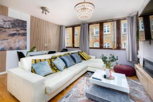 ein Wohnzimmer mit einem weißen Sofa und einem TV in der Unterkunft Charming GEM II 2BD 2BA Retreat in London