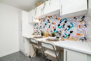 una cocina con una mesa con sillas y una pared de mosaico en Charming GEM II 2BD 2BA Retreat, en Londres