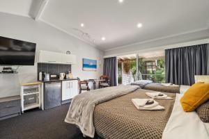 a bedroom with a large bed with towels on it at Forest Lodge Resort in Pemberton