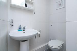 a white bathroom with a sink and a toilet at Charming GEM II 2BD 2BA Retreat in London